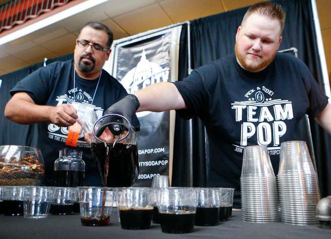 Scott May, right, and Brian Adams, of Top City Soda Pop Co., set out more of their newly released cream soda during Tuesday afternoon's Business Expo at the Ramada Hotel and Convention Center, 420 S.E. 6th.