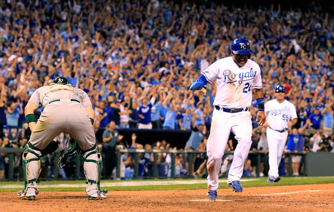 Kansas City Royals' Christian Colon scores the game-winning run past Oakland Athletics catcher Derek Norris during the 12th inning of the AL wild-card playoff baseball game on Sept. 30 in Kansas City, Mo. The Royals won 9-8.