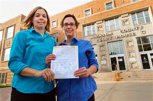 Angela Schaefer, left, and her partner, Jennifer Schaefer, hold an application for a marriage license at the clerk's office at the Johnson County Courthouse in Olathe.
