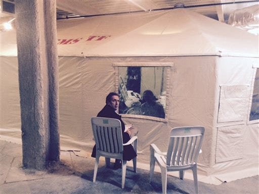 In this Sunday, Oct. 26, 2014 photo provided by attorney Steven Hyman, quarantined nurse Kaci Hickox meets with the prominent New York civil rights attorney Norman Siegel, seated, at the isolation tent at University Hospital in Newark, N.J., where Hickox was confined after flying into Newark Liberty International Airport following her work in West Africa caring for Ebola patients. Hickox, the first person forced into a mandatory quarantine in the state, was released Monday but has complained about her treatment. Following her release Siegal said "We are pleased that the state of New Jersey has decided to release Kaci. They had no justification to confine her," and added that she has not ruled out legal action. (AP Photo/Steven Hyman) MANDATORY CREDIT
