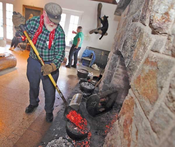 Photo by Marie Dirle/New Jersey Herald - Rob Barth, a Friends of High Point State Park volunteer, feeds the hearth during open hearth cooking Saturday at the Interpretive Center’s fireplace at High Point State Park.