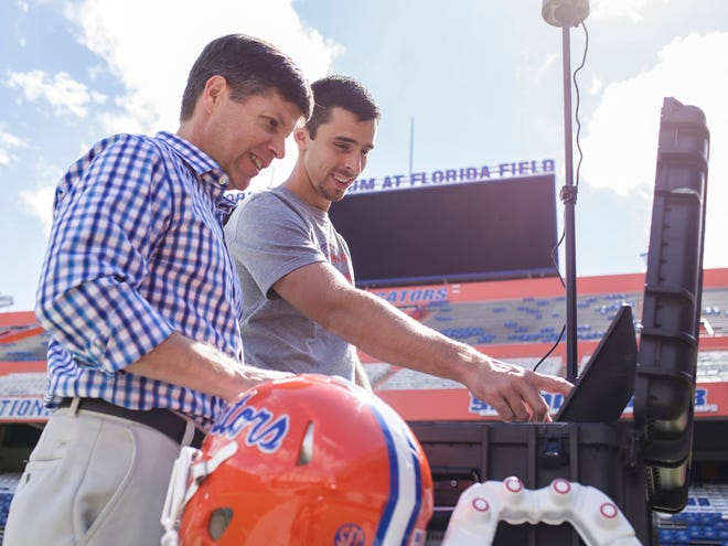Dr. James Clugston and Matt Graham, coordinator for the head impact telemetry system at the University of Florida, set up the system inside Ben Hill Griffin Stadium.