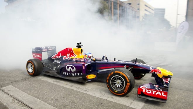 Four-time F1 world champion Sebastian Vettel, of Infiniti Red Bull Racing, speeds down Congress Avenue in his 2011 championship car on Wednesday. Hundreds watched as Vettel and his teammate Daniel Ricciardo took turns speeding the car between Seventh and 11th streets.