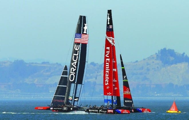 Oracle Team USA, left, leads Emirates Team New Zealand and ultimately wins the 12th race of the America’s Cup on Sept. 19, 2013, in San Francisco. AP PHOTO