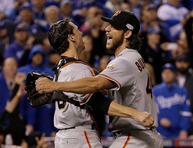 San Francisco Giants pitcher' Madison Bumgarner and catcher Buster Posey celebrate after Game 7 of baseball's World Series against the Kansas City Royals Wednesday, Oct. 29, 2014, in Kansas City, Mo. The Giants won 3-2 to win the series.
