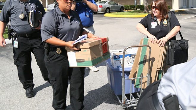 State Division of Insurance Fraud officers remove documents from an attorney's office on North Federal Highway in Boca Raton Thursday, October 30, 2014. Five people have been arrested already and authorities are searching for two more.  (Lannis Waters / The Palm Beach Post)