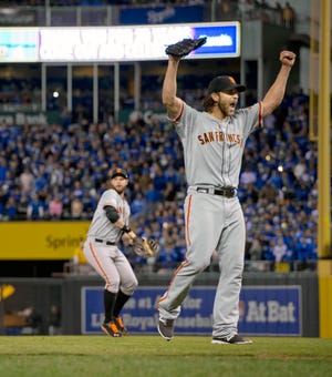 Madison Bumgarner (40) raises his arms after Pablo Sandoval catches the out clinching the World Series for the Giants.
