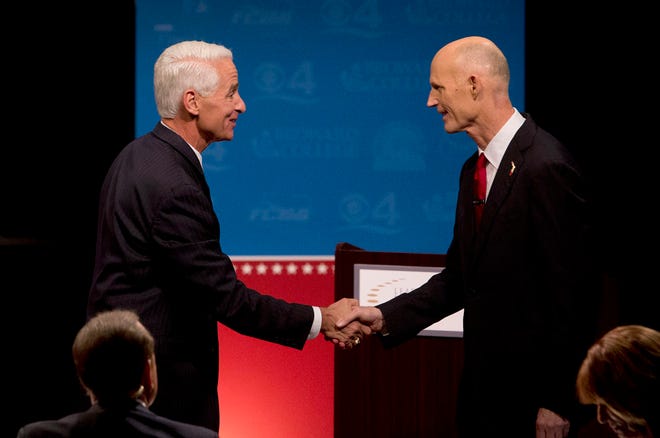 This Oct. 15, 2014, arefile photo shows Democratic challenger, former Republican Gov. Charlie Crist, left, and Florida Republican Gov. Rick Scott, shaking hands after participating in their second debate in Davie, Fla. Polls show Scott running neck-and-neck with Crist.