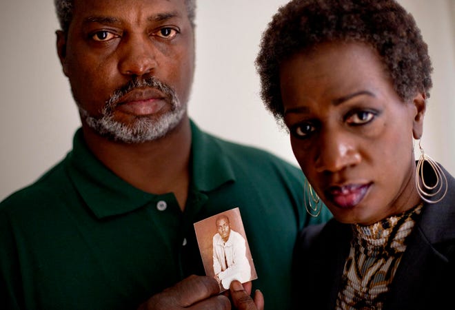 In this May 23, 2012 file photo, Pam Champion, right, and Robert Champion, Sr., left, hold a photo of their son, Robert, a Florida A&M University drum major who died in a hazing incident, as they are photographed in their attorney's office following a press conference in Atlanta.