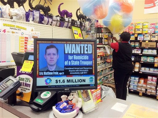 FILE - In this Sept. 20, 2014, file photo, a wanted advertisement for Eric Frein is displayed at a grocery store in Philadelphia. Authorities said Thursday, Oct. 30, 2014, that they have captured Frein, who had been eluding police, but is charged with killing one Pennsylvania State Trooper and seriously wounding another in a late night ambush.  (AP Photo/Matt Rourke, File)