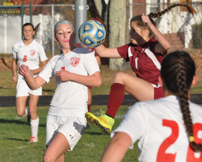 Spaulding’s Justine Carey, left, looks at a ball at eye level as Concord’s Madysen Audet closes in during Division I playoff action Thursday in Rochester.