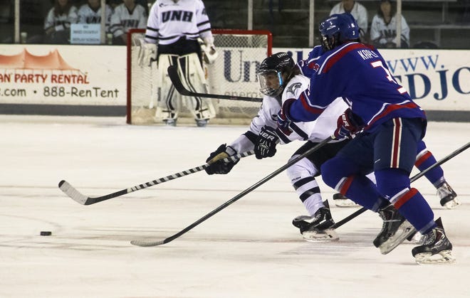 Shawn St. Hilaire/Democrat photo

UNH's Tyler Kelleher outhustles two UMass-Lowell defenders for the puck at center ice during Friday night's game at the Whittemore Center in Durham.