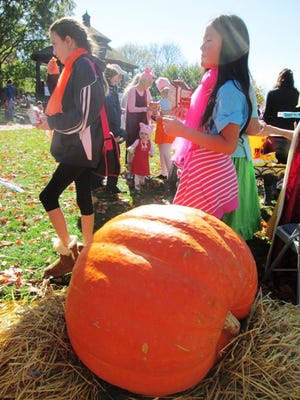 Members of Natick Drama Workshop hand out programs in front of the giant pumpkin during the annual Spooktacular on Oct. 25 at the Common.



Wicked Local Photo / Maureen Sullivan