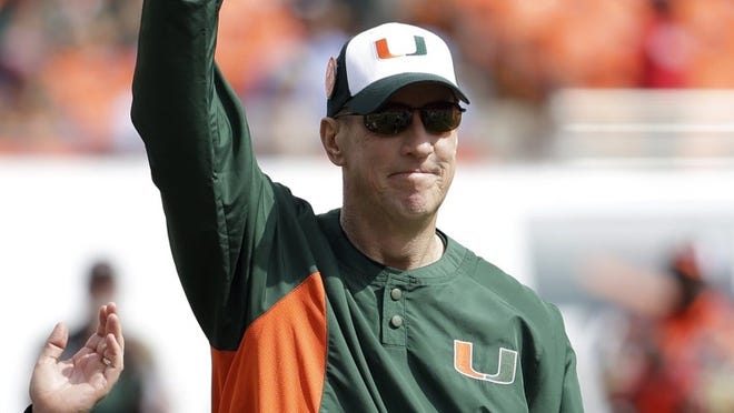 Former Miami quarterback Jim Kelly acknowledges the crowd after being presented with a game ball as he is named honorary captain before the Hurricanes’ victory over North Carolina on Saturday. (AP Photo/Lynne Sladky)
