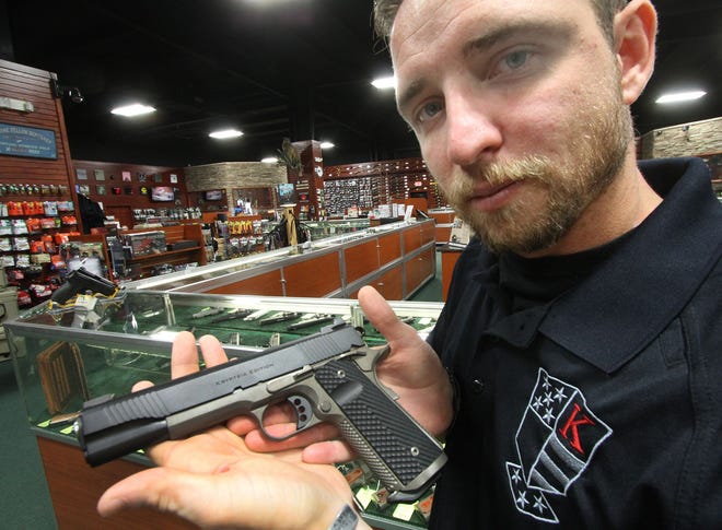 Danny Robertson of New Smyrna Beach, co-owner of Krypteia Strategies, displays a Krypteia Edition Ed Brown 1911 handgun at the Florida Gun Exchange in Ormond Beach. Robertson and business partner Mike Goble designed the limited edition handgun in collaboration with Ed Brown Products.