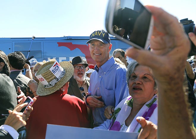 Governor Rick Scott, center, works the crowd as he campaigns in Hialeah on Sunday.