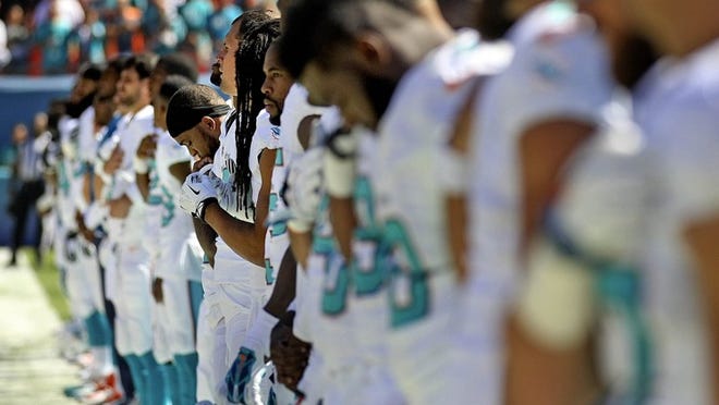 Dolphins players observe a moment of silence before Sunday’s game in memory of Paul Philbin, the father of coach Joe Philbin. Paul Philbin, 93, died Friday in Massachusetts. (Bill Ingram / Palm Beach Post)Beach Post)