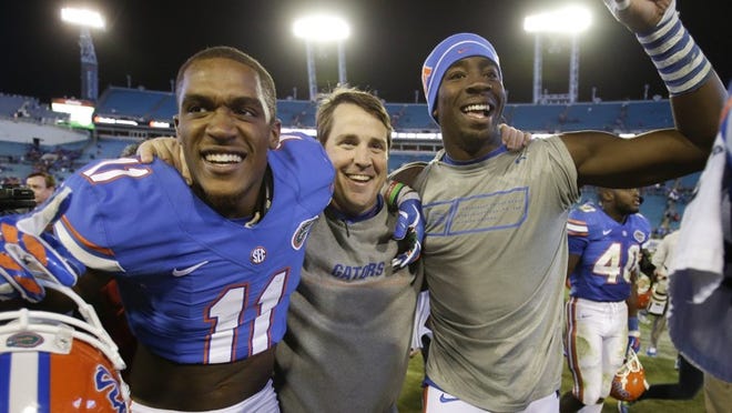 Coach Will Muschamp celebrates with wide receiver Demarcus Robinson, left, and defensive lineman Alex McCalister after the Gators’ 38-20 victory over Georgia on Saturday. (AP Photo/John Raoux)