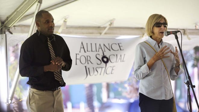 West Palm Beach Mayor Jeri Muoio speaks during a Souls To The Polls event in Howard Park Sunday, November 2, 2014. At left is Pastor Cameron Ellis of Christian Deliverance House of Prayer. (Bruce R. Bennett / The Palm Beach Post)