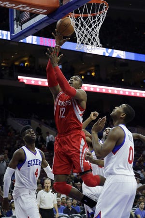 The Rockets' Dwight Howard (12) goes up for a shot as the Sixers' Nerlens Noel (4) and Brandon Davies (0) watch during Monday night's game at the Wells Fargo Center.