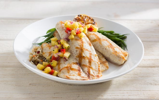 This photo provided by Red Lobster shows its Wood Grilled Tilapia on a circular plate on which slabs of fish are piled over the rice, an architectural presentation that is common at higher-end restaurants. The new plating style marks the latest attempt by the struggling seafood to right its course as it embarks on a new era.
