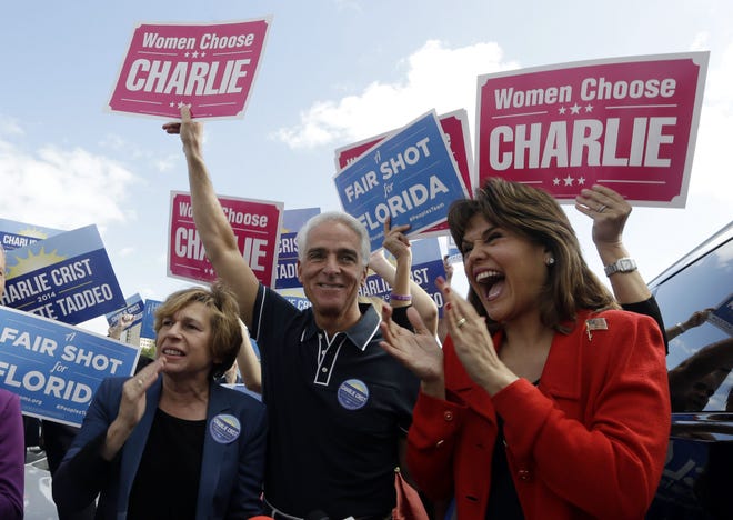 Democratic gubernatorial candidate Charlie Crist, center, and his running mate Annette Taddeo, right, cheer with supporters as they campaign at the International Brotherhood of Electrical Workers Hall, Monday, Nov. 3, 2014, in Miami. Crist, a former Florida Republican governor, is running against Republican Florida Gov. Rick Scott. At left is Randi Weingarten, president of the American Federation of Teachers.