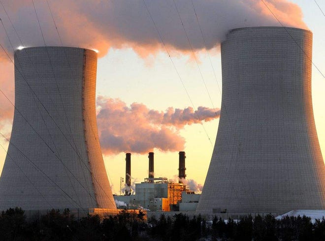 The Brayton Point Power Station is seen between its 500-foot-tall cooling towers in this January photo. The three stacks visible are those of the three coal-fired units of the plant.