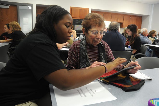 eTeam instructor Makayla Longdon, an 11th grader at East Stroudsburg South helps Marlene Mandel of Stroudsburg with her iPad mini during the one on one session of the community technology training , which is held monthly at the Carl T. Secor Administration Center on East Stroudsburg South campus.  Mandel has been using the resources of the program since its inception. For more photos go to www.poconorecord.com/photos. (Melissa Evanko/Pocono Record)