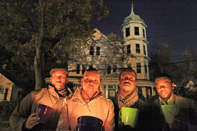 Rally participants, from left, Taino Palermo, Michell Bridges, Kobi Dennis and Chace Baptista gather Monday night at the vacant property on Higgins Avenue in Providence where John Hope Settlement House once ran a group home.