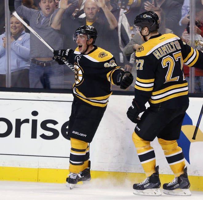 Brad Marchand (left) celebrates after scoring in overtime to give the Bruins a 2-1 win over the Panthers on Tuesday night at TD Garden.