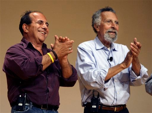 In this June 19, 2008 photo, brothers Ray, left, and Tom Magliozzi, co-hosts of National Public Radio's "Car Talk" show, applaud during a premier of a cartoon show about them in Cambridge, Mass. NPR says Tom Magliozzi died Monday, Nov. 3, 2014 of complications from Alzheimer's disease. He was 77. (AP Photo/Charles Krupa)