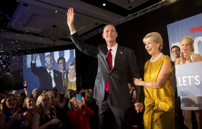 Gov. Rick Scott waves to the crowd as he and his wife Ann walk into the crowd during a victory party after defeating Democratic challenger, former Republican Charlie Crist,, Tuesday, Nov. 4, 2014 in Bonita Springs.