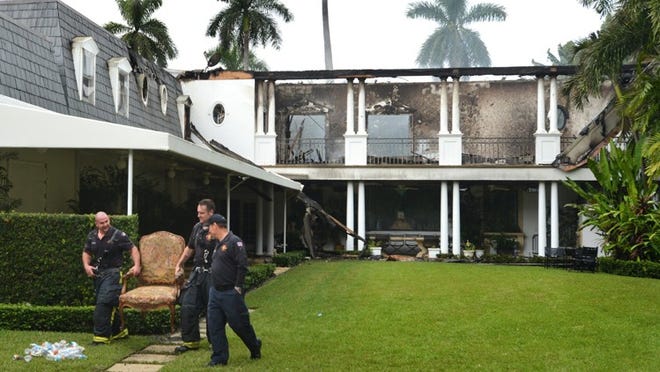 Palm Beach Fire Rescue workers remove a family heirloom from 417 Primevera Ave. on Tuesday morning.