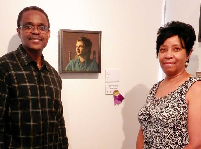 Special/ Abner Cole and his wife, Sandra Cole, stand at his winning artwork from the OCAF exhibit.