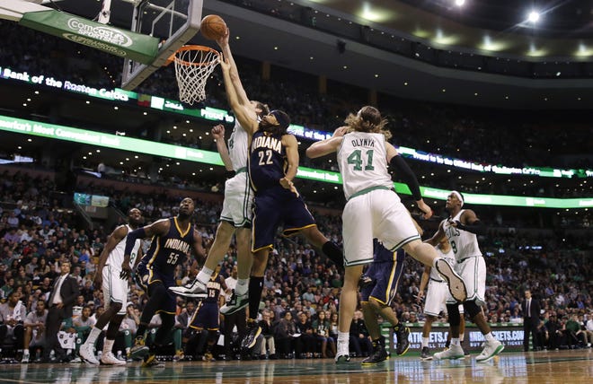 Indiana Pacers forward Chris Copeland (22) is blocked by Boston Celtics center Tyler Zeller on a drive to the basket during the second quarter of an NBA basketball game in Boston, Friday, Nov. 7, 2014. At right is Celtics center Kelly Olynyk. (AP Photo/Charles Krupa) ORG XMIT: MACK107