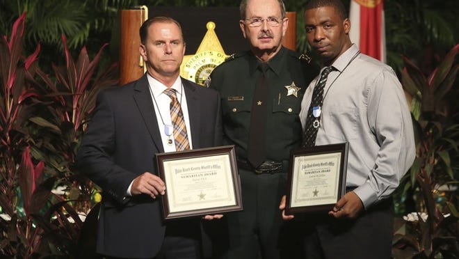 David Fitch (left) and Central McClellion (right) received the Samaritan Award from Sheriff Ric Bradshaw during the Palm Beach County Sheriff’s Office 2014 Annual Awards Ceremony at the Palm Beach County Convention Center Friday, November 7, 2014. (Bruce R. Bennett / The Palm Beach Post)