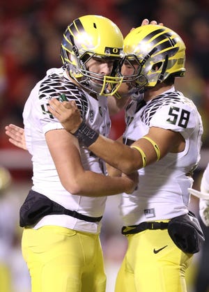 Oregon placekicker Aidan Schneider is congratulated by long snapper Tanner Carew following his fourth-quarter field goal. (Andy Nelson/The Register-Guard)