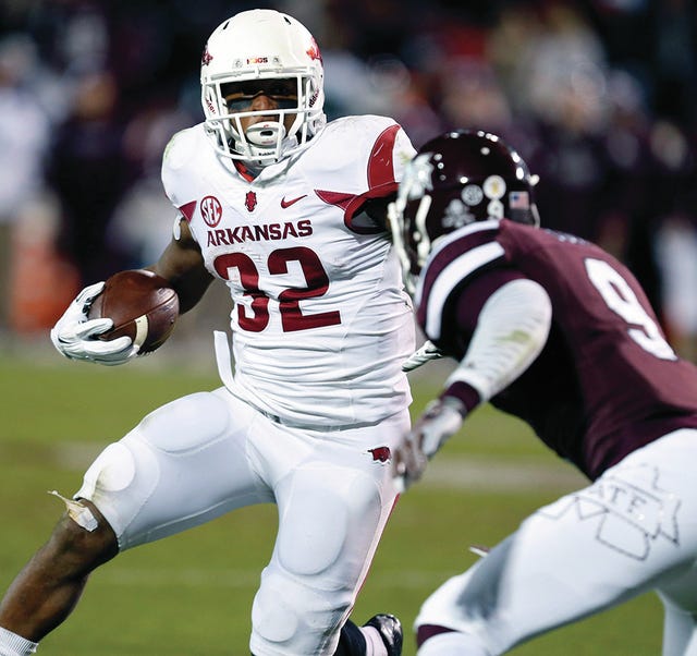 Arkansas running back Jonathan Williams (32) tries to run around the defense of Mississippi State defensive back Justin Cox (9) in the second half of an NCAA college football game in Starkville, Miss., Saturday, Nov. 1, 2014. No. 1 Mississippi State won 17-10. (AP Photo/Rogelio V. Solis)