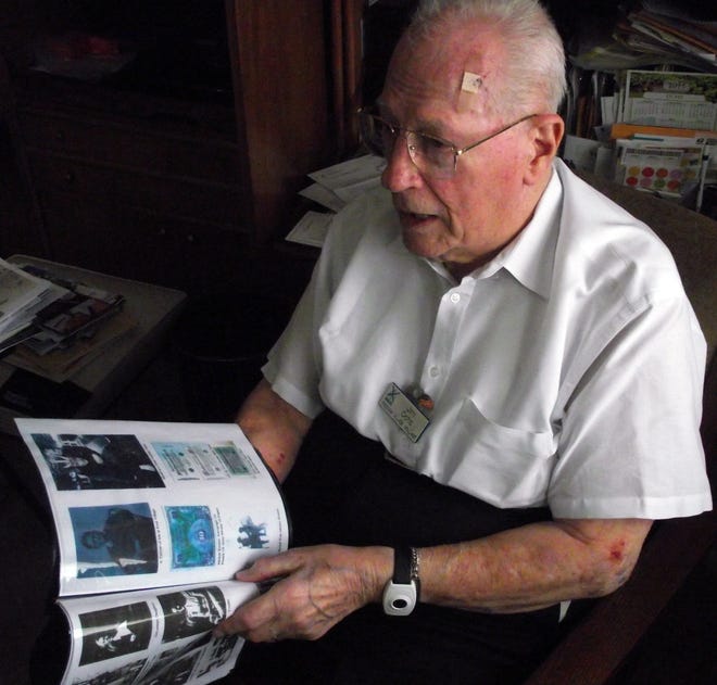 John Ochs at Freedom Village in Holland looks through photos from World War II. Jim Hayden/Sentinel staff