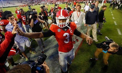 FILE - In this Oct. 4, 2014, Georgia running back Todd Gurley (3) celebrates with fans after defeating Vanderbilt 44-17 in an NCAA college football game in Athens, Ga. After serving a four-game suspension for taking money for autographs, Georgia's star running back returns for a big one _ the 16th-ranked Bulldogs hosting ninth-ranked Auburn.(AP Photo/John Bazemore, File)