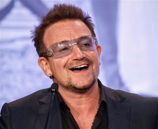 FILE - In this Friday, May 18, 2012 file photo, Bono, the Irish rock star and activist, speaks at the Symposium on Global Agriculture and Food Security following an appearance by President Barack Obama at the Ronald Reagan Building in Washington. Berlin airport authorities say U2 front man Bono's private plane lost a hatch as it was coming in for a landing on Wednesday Nov. 13, 2014, in the German capital but the Irish singer was never in any danger. (AP Photo/J. Scott Applewhite, File)