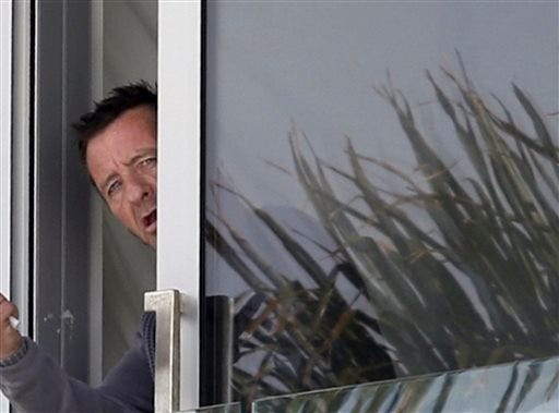 In this Thursday, Nov. 6, 2014 file photo, Phil Rudd, drummer for the rock band AC/DC, gestures from a window at his house in Tauranga, New Zealand. Angus Young of AC/DC says his band mates have not been in touch with Rudd since he was charged with threatening to kill and possessing methamphetamine and marijuana last week. Young, 59, said in an interview Thursday, Nov. 13, 2014, that Rudd's behavior had been somewhat erratic during the recording of their new album. (AP Photo/New Zealand Herald, John Borren, File) NEW ZEALAND OUT, AUSTRALIA OUT