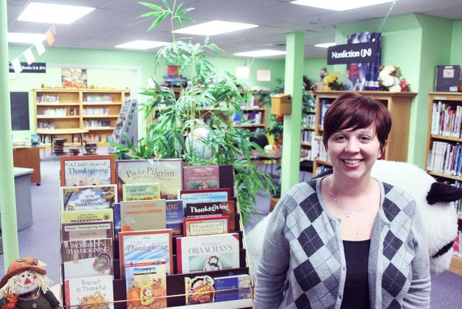 The Warren County Public Library's new children's librarian, Danielle Foust, poses beside a display of Thanksgiving-themed books inside the children's room. Having started the job on Monday, Foust is already taking steps to forge long-lasting relationships with the community.