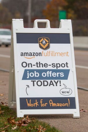 A sign advertises a job fair in Norwood on Wednesday for the new Amazon distribution center in Stoughton.