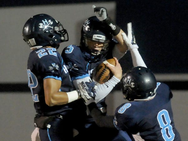 Hoggard's Harrison Smith, left, Austin Schoenleber, center, and Evan Allegret celebrate a touchdown against South Central High School in the first round of football playoffs Friday November 14, 2014.