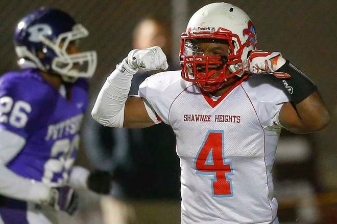 Shawnee Heights' Tony Barksdale flexes his muscles after scoring a touchdown in the third quarter of Friday night's Class 5A quarterfinals game against Pittsburg.