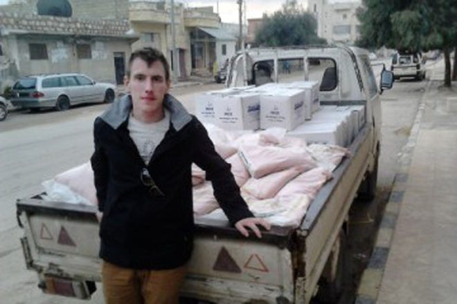 In this undated photo provided by the Kassig Family, Peter Kassig, is shown with a truck loaded with supplies. The Islamic State group released a graphic video on Sunday, Nov. 16, 2014, in which a black-clad militant claimed to have beheaded U.S. aid worker Peter Kassig, who was providing medical aid to Syrians fleeing the civil war when he was captured inside Syria on Oct. 1, 2013. His friends say he converted to Islam in captivity and took the first name Abdul-Rahman.