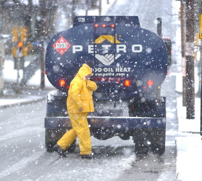 An oil delivery man bundles up against the snow as he prepares to make a delivery in Fall River.