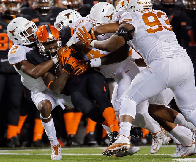 Oklahoma State receiver James Washington is gang tackled by several Texas defenders at Boone Pickens Stadium on Nov. 15, 2014. Photo by Sarah Phipps / The Oklahoman.