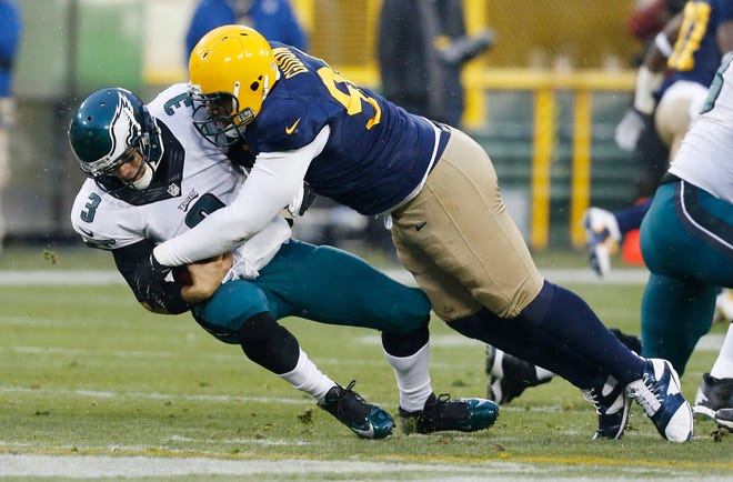 Green Bay Packers' Letroy Guion sacks Philadelphia Eagles' Mark Sanchez during the first half of an NFL football game Sunday, Nov. 16, 2014, in Green Bay, Wis. (AP Photo/Mike Roemer)